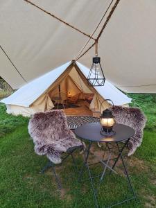 LabroyeAu Pied Du Trieu, the glamping experience的帐篷前配有2把椅子和1张桌子