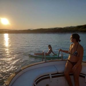 波尔图圣保罗Sleep in the bay on my boat的两个穿着泳衣的女人在水中划船