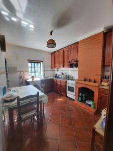 布朗库堡Casa Penafalcão的厨房配有木制橱柜、桌子和壁炉。