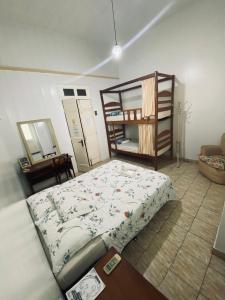 马瑙斯Aldeia Hostel的一间卧室配有一张床,另一间双层床间配有架子