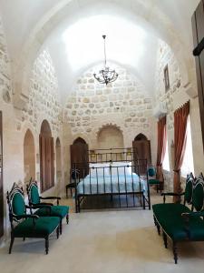 马尔丁Mardin tarihi ulu Cami yanı, tarihi Konak的一间卧室,卧室内配有一张床和椅子