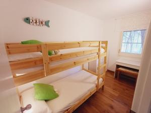 帕尔斯Apartamento con piscina cerca de la playa的一间卧室配有两张双层床和绿色枕头
