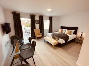 丰沙尔Living Funchal iNN的一间卧室配有一张床、一把椅子和一张桌子