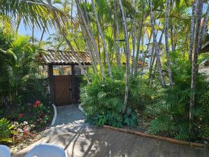 布希奥斯Suite Dupla em Búzios的一个带木门和棕榈树的花园