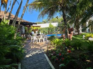 布希奥斯Suite Dupla em Búzios的一个带桌椅和棕榈树的庭院