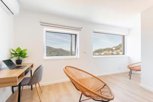 洛里加Loriga View Apartments的白色的客房配有桌椅和2扇窗户。
