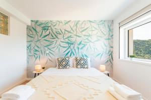 洛里加Loriga View Apartments的卧室配有一张带热带壁画的床铺。
