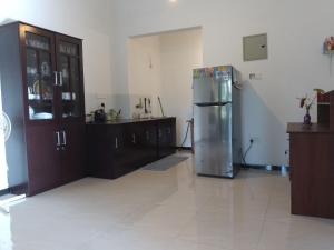 乌纳瓦图纳Sea & Greens Apartments的厨房配有不锈钢冰箱和木制橱柜