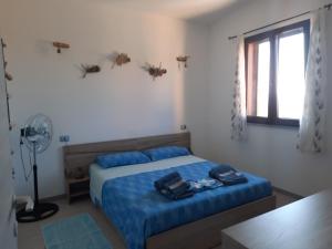 托雷戴科尔萨里Villa Margherita vista mare的一间卧室配有一张带蓝色床单的床和一扇窗户。