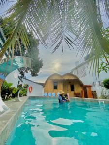 Batang BerjuntaiVilla Motel Mas Guesthouse的坐在游泳池的水里的人