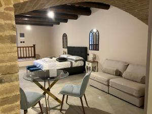 诺切劳恩布拉Residenza il Duomo的一间卧室配有一张床、一张沙发和一张桌子