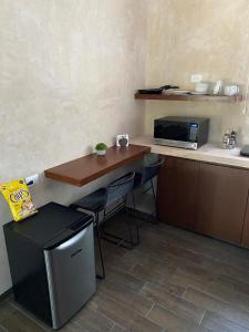 梅里达Hotelito YUM KAAX的一间带桌子和微波炉的小厨房