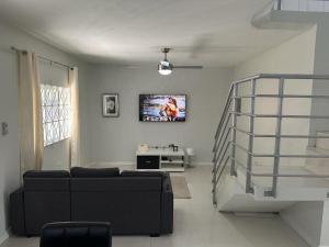曼德维尔Mandeville Vacation Home的客厅配有沙发和墙上的电视