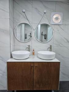首尔明洞菲尔斯泰精品女性旅馆的浴室设有2个水槽和2个镜子
