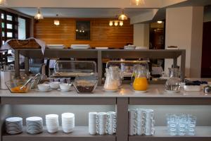 巴拉斯港Hotel Germania的厨房配有带盘子和橙汁的柜台