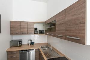 杜塞尔多夫T&K Apartments - 2 Room Apartment - Ground Floor的一个带木制橱柜和水槽的厨房