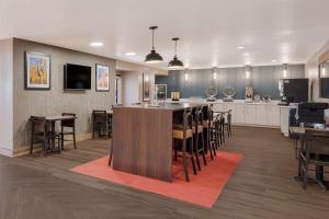 弗拉格斯塔夫弗拉格斯塔夫/贝里蒙特戴斯酒店的一间大厨房以及带酒吧和椅子的用餐室