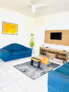 里约热内卢Carvalho de Paquetá的客厅配有2张蓝色沙发和电视