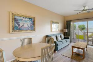 鸭礁岛Reef House的客厅配有桌子和沙发