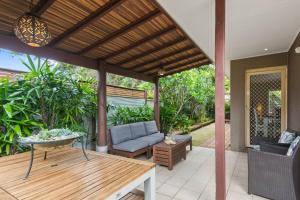 BellambiThalassa Escape - Coastal Chic with Balinese Patio的户外庭院配有沙发和桌子