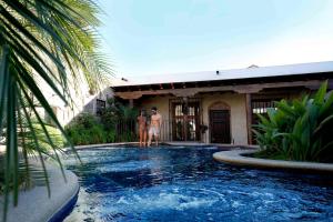 危地马拉安地瓜安提瓜卡米诺雷亚度假酒店的两个人站在房子前面的游泳池里