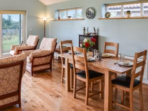 Old BuckenhamCedar Lodge的一间带木桌和椅子的用餐室
