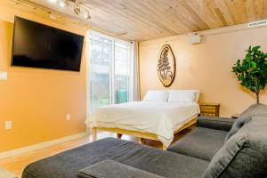 波特兰Portland Urban Lodge, Quiet, Walkable, Near的一间卧室配有一张床、一台电视和一张沙发