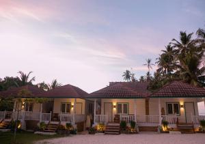 KatietKatiet Beach Resort Mentawai Lances Right HTS的一座带门廊和棕榈树的房子