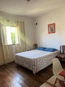 伊塔年杜Casa de campo com piscina, mesa de bilhar e 3 quartos的一间卧室设有一张床和一个窗口