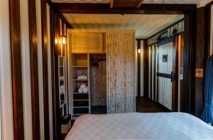 今归仁村Vacation Village Okinawa - Yambaru的一间卧室配有一张床和一个带架子的衣柜
