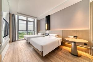 杭州杭州西湖万怡酒店的酒店客房设有两张床和一张桌子。