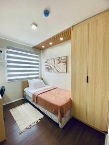 伊洛伊洛Riverview Two Bedroom Condo at One Spatial Iloilo的一间带一张床和一个衣柜的小卧室