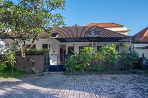 沙努尔Asri Bali Sanur Apartment的前面有砖瓦车道的房子