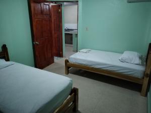 佩诺诺梅La Casa Buena Esperanza的一间设有两张床的房间和一扇通往卧室的门
