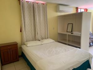马那瓜Open house的一间小卧室,配有一张床和一个梳妆台
