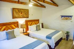 康塞普西翁德阿塔科Hotel Casa Pino, Tu Casa en Ataco的配有两张床的酒店客房中的两张床