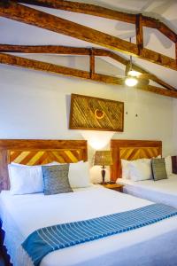 康塞普西翁德阿塔科Hotel Casa Pino, Tu Casa en Ataco的木梁客房的两张床