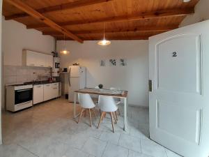 里奥加耶戈斯AYRES DEL SUR Patagonia的厨房配有桌椅和冰箱。