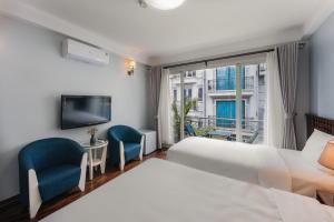 河内Cheers Hostel Hanoi的酒店客房设有一张床、两把椅子和一扇窗户。