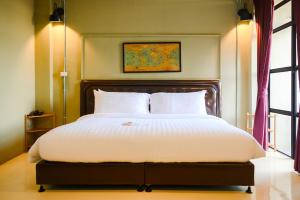 乌隆他尼Dream Factory Hotel的一间卧室配有一张带白色床单的大床