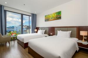 岘港Aria Grand Hotel & Spa的酒店客房设有两张床和窗户。