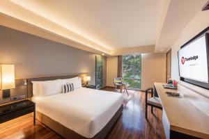 曼谷Travelodge Sukhumvit 11的配有一张床和一台平面电视的酒店客房