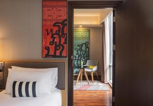 曼谷Travelodge Sukhumvit 11的一间卧室配有一张床,另一间卧室配有椅子