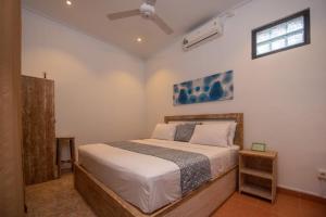沙努尔Asri BALI SANUR Premier Suites的一间卧室配有一张床和吊扇