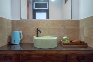 沙努尔Asri BALI SANUR Premier Suites的一间带位于柜台的绿色浴缸的浴室