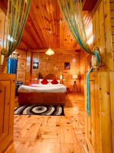 马拉里Shree Ram Cottage, Manali ! 1,2,3 Bedroom Luxury Cottages Available的木制客房内的一间卧室,配有一张床