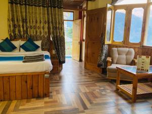 马拉里Shree Ram Cottage, Manali ! 1,2,3 Bedroom Luxury Cottages Available的一间卧室配有一张床、一把椅子和一张桌子