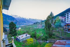 马拉里Shree Ram Cottage, Manali ! 1,2,3 Bedroom Luxury Cottages Available的享有山谷和山丘上房屋的景色