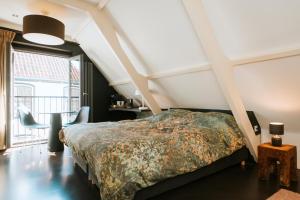 登堡Texels Goud Deluxe Suites的一间卧室设有一张床和一个大窗户