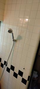 秩父市きっとあい楽館的浴室铺有黑白瓷砖,设有淋浴。